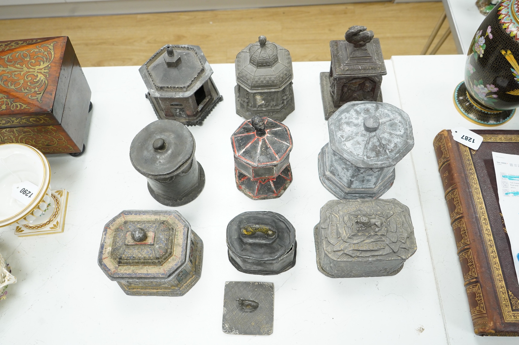 A collection of nine early 19th century lead tobacco boxes and a cover, tallest 20cm